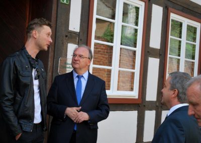 Im Gespräch mit Wiener Künstler Andreas Werner sind Landrat Michael Ziche und Ministerpräsident Reiner Haseloff vor dem Stipendiatenhaus