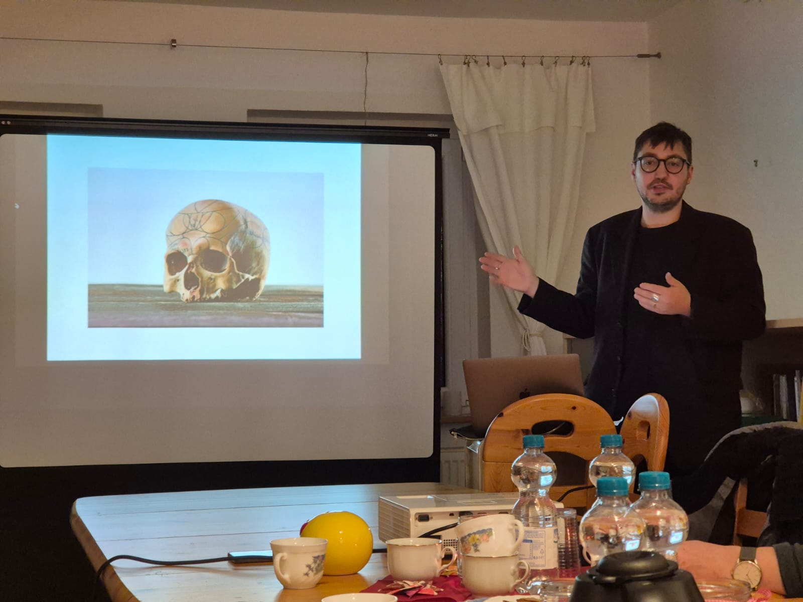 Weilandt vor einer Schädelzeichnung während seiner Präsentation